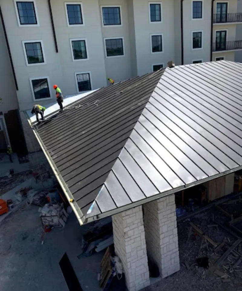 Crew installing standing seam metal roof panels on a commercial project in Miami Gardens